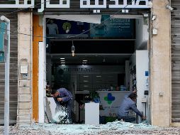 Trabajadores limpian los cristales rotos de una farmacia tras un ataque israelí en la zona de Al Chiyah, un suburbio al sur de Beirut, Líbano. EFE/W. Hamzeh