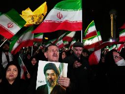 Iraníes ondean banderas durante un acto en apoyo a su gobierno en una plaza en el oeste de Teherán. AP/V. Salemi