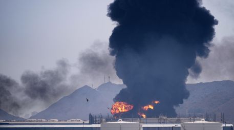 Una llamarada y una columna de humo se elevan tras el impacto de los restos de un dron iraní interceptado contra una instalación petrolera en Fujairah, Emiratos Árabes Unidos. AP/A. Qadri