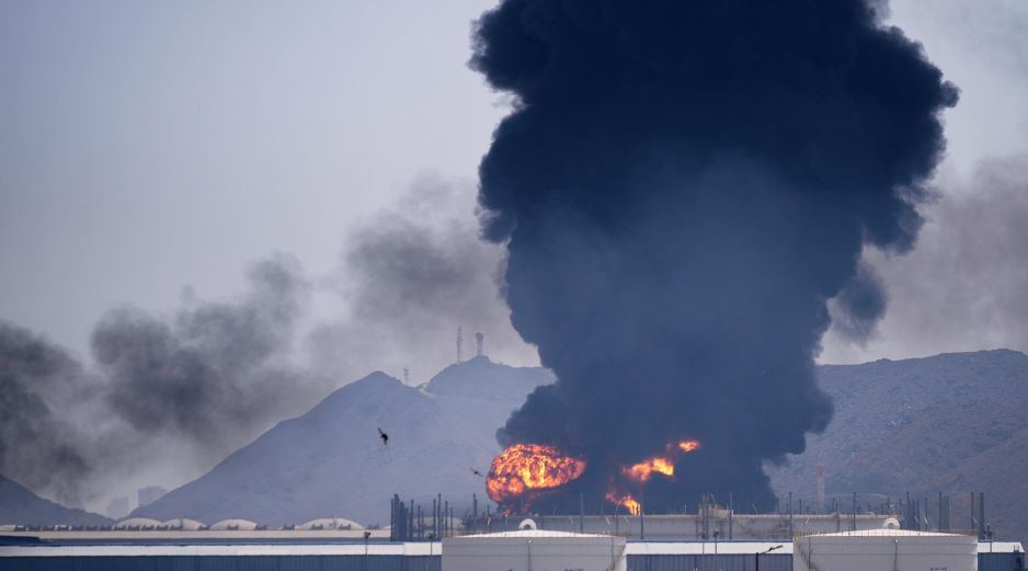 Una llamarada y una columna de humo se elevan tras el impacto de los restos de un dron iraní interceptado contra una instalación petrolera en Fujairah, Emiratos Árabes Unidos. AP/A. Qadri