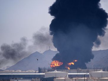 Una llamarada y una columna de humo se elevan tras el impacto de los restos de un dron iraní interceptado contra una instalación petrolera en Fujairah, Emiratos Árabes Unidos. AP/A. Qadri