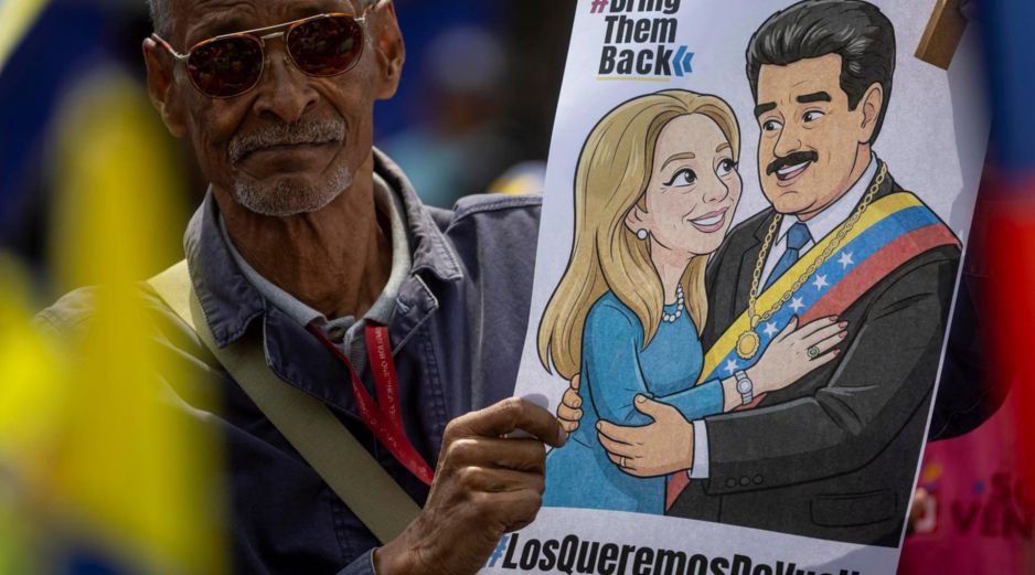 Un hombre sostiene un cartel con la imagen de Nicolás Maduro junto a su esposa, Cilia Flores, durante una manifestación en Caracas. EFE/M. Gutiérrez
