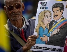 Un hombre sostiene un cartel con la imagen de Nicolás Maduro junto a su esposa, Cilia Flores, durante una manifestación en Caracas. EFE/M. Gutiérrez
