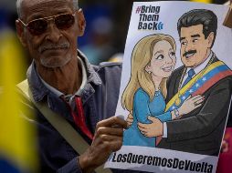 Un hombre sostiene un cartel con la imagen de Nicolás Maduro junto a su esposa, Cilia Flores, durante una manifestación en Caracas. EFE/M. Gutiérrez