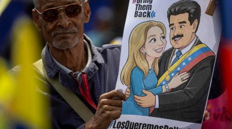 Un hombre sostiene un cartel con la imagen de Nicolás Maduro junto a su esposa, Cilia Flores, durante una manifestación en Caracas. EFE/M. Gutiérrez