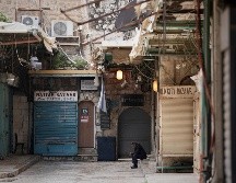 Un hombre se sienta junto a una puerta de la iglesia del Santo Sepulcro que permanece cerrada. AP/M. Illean