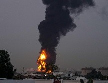 Fuego y una columna de humo se elevan tras el impacto de un dron contra un tanque de combustible cerca del Aeropuerto Internacional de Dubái, en los Emiratos Árabes Unidos. AP