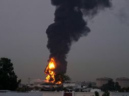 Fuego y una columna de humo se elevan tras el impacto de un dron contra un tanque de combustible cerca del Aeropuerto Internacional de Dubái, en los Emiratos Árabes Unidos. AP