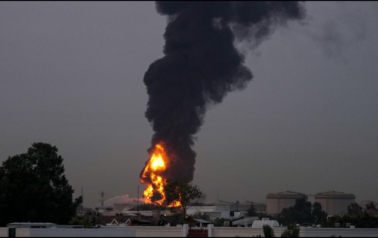 Fuego y una columna de humo se elevan tras el impacto de un dron contra un tanque de combustible cerca del Aeropuerto Internacional de Dubái, en los Emiratos Árabes Unidos. AP