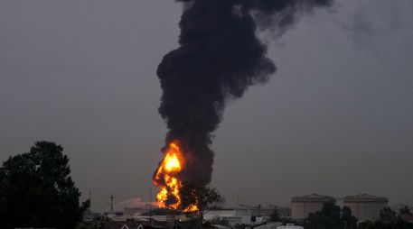 Fuego y una columna de humo se elevan tras el impacto de un dron contra un tanque de combustible cerca del Aeropuerto Internacional de Dubái, en los Emiratos Árabes Unidos. AP