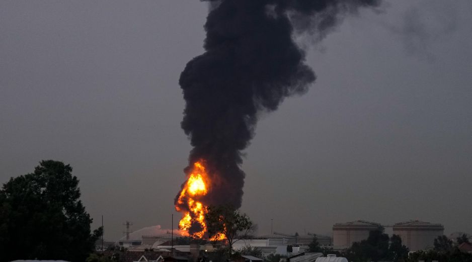 Fuego y una columna de humo se elevan tras el impacto de un dron contra un tanque de combustible cerca del Aeropuerto Internacional de Dubái, en los Emiratos Árabes Unidos. AP