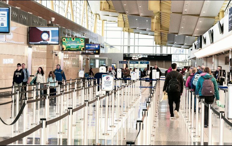 Viajeros transitan por filtros de seguridad con menor afluencia en el Aeropuerto Ronald Reagan de Washington, tras el pago de salarios atrasados a agentes de seguridad, lo que ayudó a reducir filas. AFP