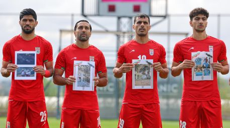 Jugadores iraníes cantan el himno nacional, sosteniendo fotografías de niños presuntamente asesinados en ataques parte de la guerra que EU e Israel sostienen contra Irán. AP / Riza Ozel