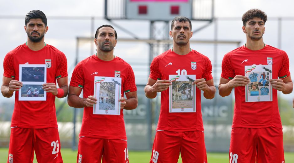 Jugadores iraníes cantan el himno nacional, sosteniendo fotografías de niños presuntamente asesinados en ataques parte de la guerra que EU e Israel sostienen contra Irán. AP / Riza Ozel