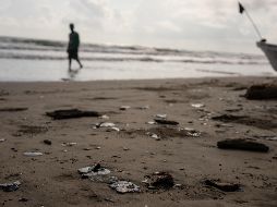 Grumos de residuos de petróleo en la costa tras la suspensión de la pesca debido a un derrame de petróleo. AP/F. Márquez
