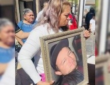 Ceci Flores sostiene una foto de tu hijo durante la misa de este jueves. SUN/ESPECIAL