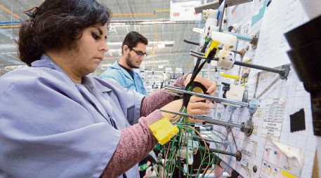 Dos operadores realizan labores en planta, en un contexto de desaceleración en la generación de empleo formal en Jalisco. ESPECIAL