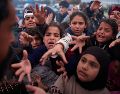 Familias desplazadas extienden las manos mientras esperan a recibir donativos de alimentos en un campamento después de huir de los bombardeos israelíes en el sur de Líbano. AP/E. Morenatti