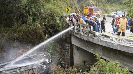 Fotografía cedida por Bomberos Cuenca que muestra a sus integrantes atendiendo el accidente de un autobús que se precipitó a un abismo y posteriormente se incendió. EFE/Bomberos Cuenca