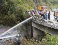 Fotografía cedida por Bomberos Cuenca que muestra a sus integrantes atendiendo el accidente de un autobús que se precipitó a un abismo y posteriormente se incendió. EFE/Bomberos Cuenca