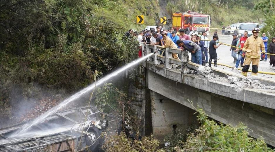 Fotografía cedida por Bomberos Cuenca que muestra a sus integrantes atendiendo el accidente de un autobús que se precipitó a un abismo y posteriormente se incendió. EFE/Bomberos Cuenca