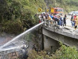 Fotografía cedida por Bomberos Cuenca que muestra a sus integrantes atendiendo el accidente de un autobús que se precipitó a un abismo y posteriormente se incendió. EFE/Bomberos Cuenca