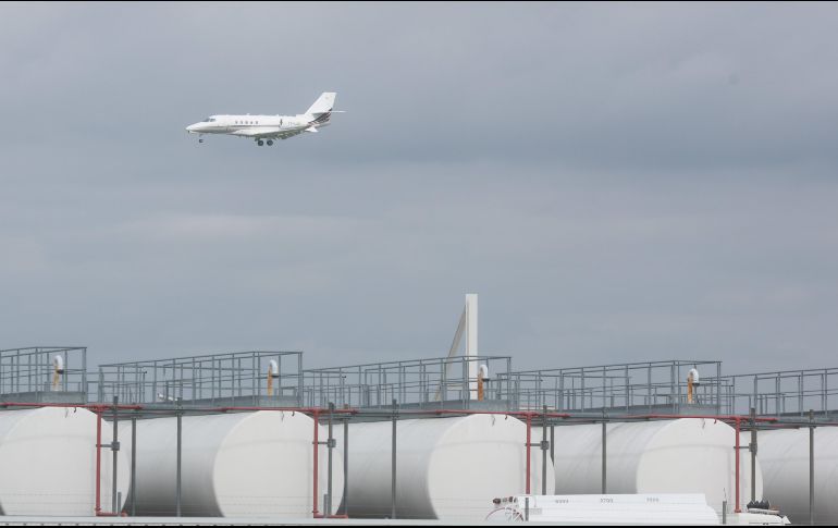 Un avión pasa sobre  instalaciones de almacenamiento de queroseno en el aeropuerto de Lieja, Bélgica. Las aerolíneas advierten de una posible escasez en las próximas semanas y la Unión Europea prepara medidas de emergencia ante las vacaciones de verano. EFE/O. Hoslet