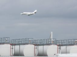 Un avión pasa sobre  instalaciones de almacenamiento de queroseno en el aeropuerto de Lieja, Bélgica. Las aerolíneas advierten de una posible escasez en las próximas semanas y la Unión Europea prepara medidas de emergencia ante las vacaciones de verano. EFE/O. Hoslet