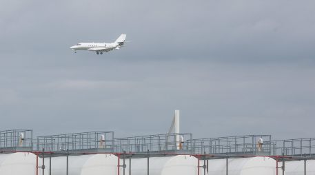 Un avión pasa sobre  instalaciones de almacenamiento de queroseno en el aeropuerto de Lieja, Bélgica. Las aerolíneas advierten de una posible escasez en las próximas semanas y la Unión Europea prepara medidas de emergencia ante las vacaciones de verano. EFE/O. Hoslet