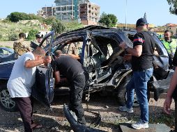 Varias personas trabajan en el lugar de un ataque aéreo israelí que impactó un vehículo en la ciudad de Jiyeh, al sur de Beirut, Líbano. EFE/W. Hamzeh