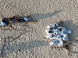 Trabajadores descansan después de llenar costales con arena contaminada con petróleo. El derrame reportado desde inicios de febrero de 2026, y que todavía sigue dejando estragos, se originó por una fuga detectada en uno de los ductos del complejo Cantarell. SUN/D. Prado