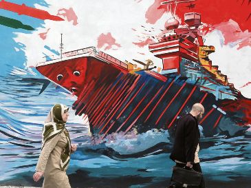 Habitantes de la capital persa caminan junto a un mural donde se exalta la fortaleza militar de su nación frente a la armada estadounidense. EFE
