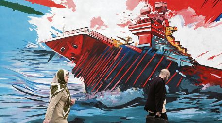 Habitantes de la capital persa caminan junto a un mural donde se exalta la fortaleza militar de su nación frente a la armada estadounidense. EFE