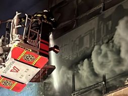 Bomberos utilizan una escalera telescópica para atacar el incendio en uno de los edificios afectados. X/JefeVulcanoCova