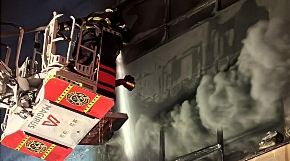 Bomberos utilizan una escalera telescópica para atacar el incendio en uno de los edificios afectados. X/JefeVulcanoCova