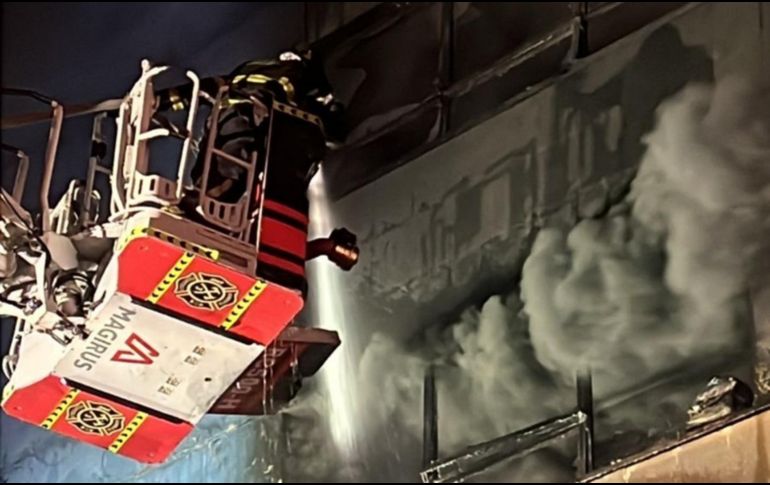 Bomberos utilizan una escalera telescópica para atacar el incendio en uno de los edificios afectados. X/JefeVulcanoCova