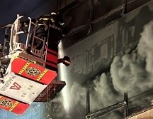 Bomberos utilizan una escalera telescópica para atacar el incendio en uno de los edificios afectados. X/JefeVulcanoCova