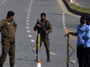 Elementos de seguridad de Pakistán montan guardia en la carretera que lleva a la Zona Roja, donde se ubican la mayoría de las misiones diplomáticas y oficinas gubernamentales, incluyendo la sede prevista para la segunda ronda de conversaciones de paz entre Estados Unidos e Irán. EFE/S. Shahzad