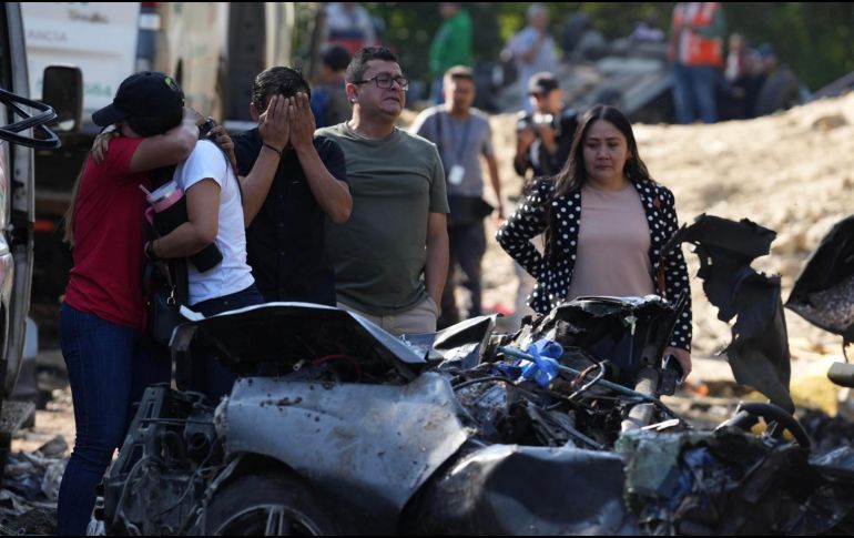 Familiares de las víctimas del atentado ocurrido en la Vía Panamericana lloran este domingo frente a los escombros de los vehículos destruidos en Cajibío, Colombia. EFE/E. Guzmán