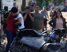 Familiares de las víctimas del atentado ocurrido en la Vía Panamericana lloran este domingo frente a los escombros de los vehículos destruidos en Cajibío, Colombia. EFE/E. Guzmán