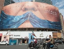 Un cartel del gobierno iraní mofándose de Trump y su problema para abrir el Estrecho de Ormuz adorna el corazón de Teherán. AFP