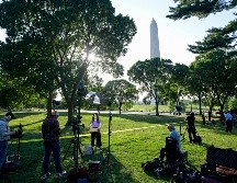 Periodistas reunidos mientras el Servicio Secreto y la policía local vigilan el lugar en donde agentes del orden balearon a una persona cerca del Monumento a Washington. AP/R. Lamkey