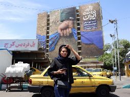 Teherán. Una mujer iraní pasa frente a un cartel con propaganda, que proclama el dominio de ese Gobierno sobre el Estrecho de Ormuz. EFE/A. Taherkenareh