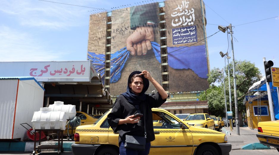 Teherán. Una mujer iraní pasa frente a un cartel con propaganda, que proclama el dominio de ese Gobierno sobre el Estrecho de Ormuz. EFE/A. Taherkenareh