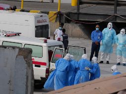 Trabajadores de salud con trajes de protección evacúan pacientes del crucero en una ambulancia en Cabo Verde. AP / M. Apawu