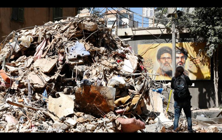 Una mujer pasea por un edificio parcialmente dañado objetivo de un ataque israelí en el barrio de Haret Hreik, suburbio sur de Beirut, Líbano. EFE/STRINGER