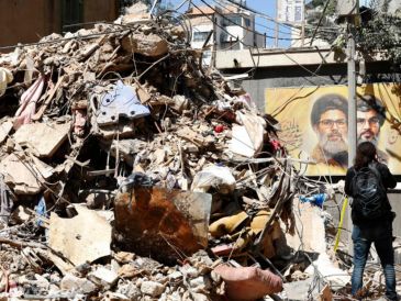 Una mujer pasea por un edificio parcialmente dañado objetivo de un ataque israelí en el barrio de Haret Hreik, suburbio sur de Beirut, Líbano. EFE/STRINGER