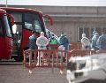 Dos de los pasajeros desembarcados que iban a bordo del crucero neerlandés MV Hondius han desembarcado ya en el puerto de Granadilla de Abona y reciben instrucciones de personal de la Unidad Militar de Emergencias y del Servicio de Sanidad Exterior. EFE/M. Barreto