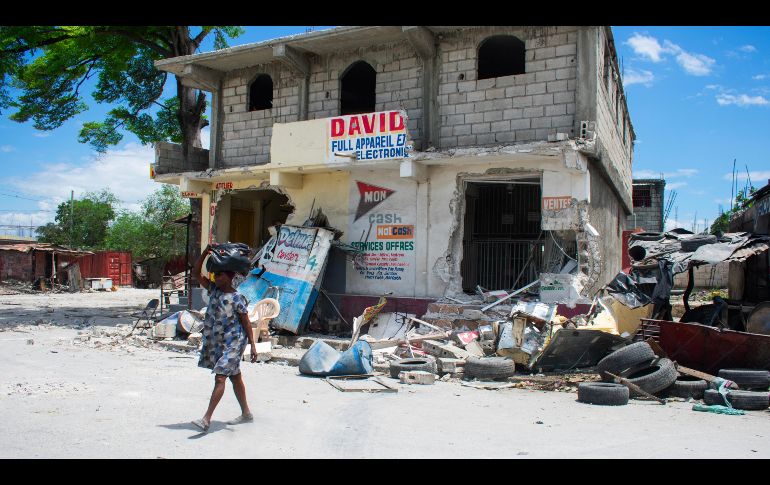 Una mujer camina con pocas pertenencias tras enfrentamientos entre grupos armados, este martes, en Puerto Príncipe. EFE/J. St Élois