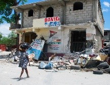 Una mujer camina con pocas pertenencias tras enfrentamientos entre grupos armados, este martes, en Puerto Príncipe. EFE/J. St Élois